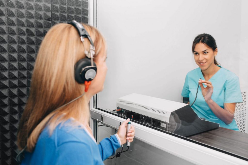 A patient undergoing a hearing test with headphones at an audiology clinic